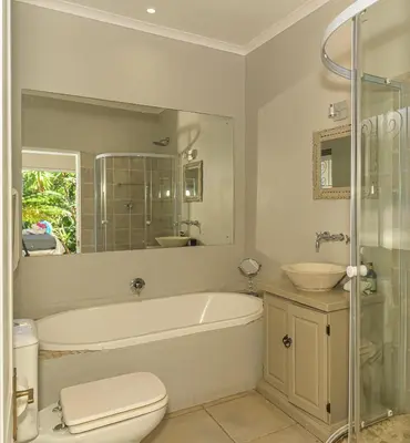 a bathroom with a tub and a toilet and a sink at Villa Blu Guesthouse in Hermanus