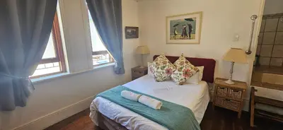 a bedroom with a bed with two pillows on it at Kelkiewyn Guesthouse Caledon in Caledon