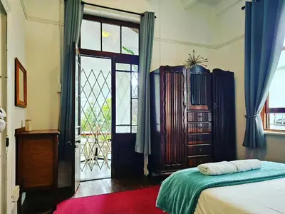 a bedroom with a bed and an open door at Kelkiewyn Guesthouse Caledon in Caledon