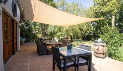 a patio with tables and chairs and a wine barrel at B&B Sauvignon Country Lodge in Wellington
