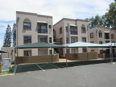a large building with blue umbrellas in front of it at Broadway Self Catering Apartments in Durbanville