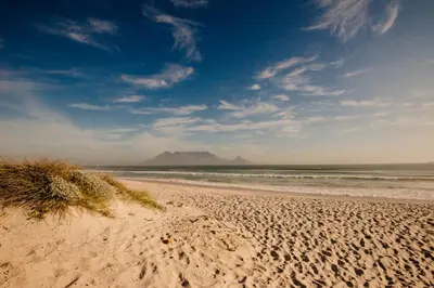 a sandy beach with a mountain in the background at Voir la Mer - Blouberg Beach in Bloubergstrand