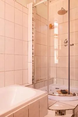 a white bathroom with a tub and a shower at Angel's Corner in Cape Town