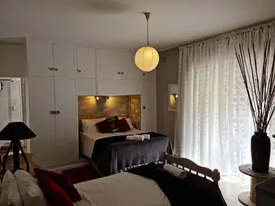 a bedroom with two beds and a large window at Angel's Corner in Cape Town