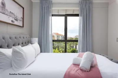 a bedroom with a large bed with a large window at Century City Boutique Apartments in Cape Town