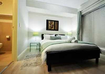 a bedroom with a large bed and a window at Century City Boutique Apartments in Cape Town