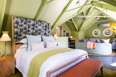 a bedroom with a large bed and a couch at Bosjes - Herehuis in Breerivier