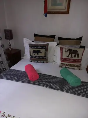 a white bed with three pillows on it at Turning Point Bed & Breakfast in Cape Town