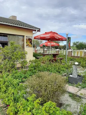 a patio with a table and a red umbrella at Turning Point Bed & Breakfast in Cape Town