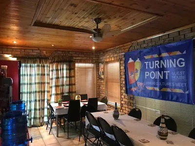 a meeting room with tables and chairs and a banner at Turning Point Bed & Breakfast in Cape Town