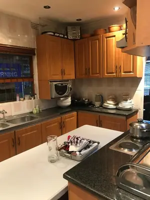 a kitchen with wooden cabinets and a counter top at Turning Point Bed & Breakfast in Cape Town