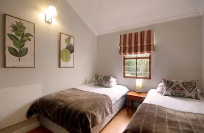a bedroom with two beds and a window at Stony Brook Cottages in Franschhoek