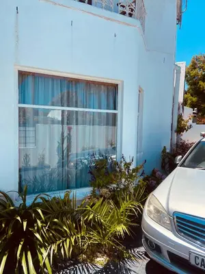 a car parked in front of a building with a window at Zagorski’s Bed and breakfast in Bloubergstrand