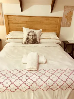 a picture of a woman on a bed with towels at Zagorski’s Bed and breakfast in Bloubergstrand