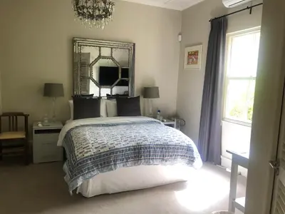 a bedroom with a bed and a mirror on the wall at Elton in Cape Town