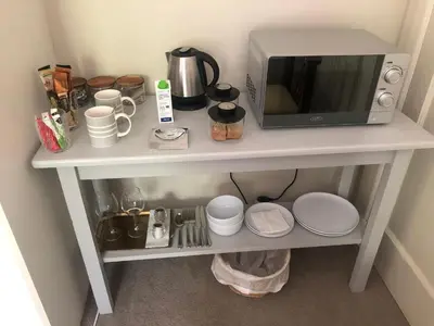 a white table with a microwave and dishes on it at Elton in Cape Town