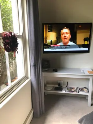a flat screen tv on a wall next to a window at Elton in Cape Town