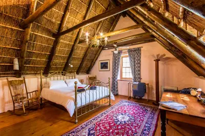 a bedroom with a bed in a room with wooden ceilings at Die Wasbak in Greyton