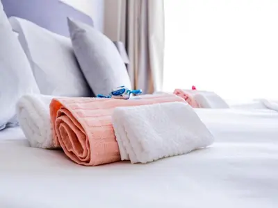 a pile of towels sitting on a bed at Worcester the Karoo Guest Room in Worcester