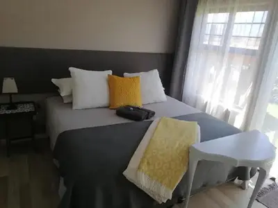 a bedroom with a large bed with yellow and white pillows at Worcester the Karoo Guest Room in Worcester