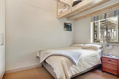 a bedroom with a bed and a window at Atlantic Blue Villa at Pilots in Cape Town