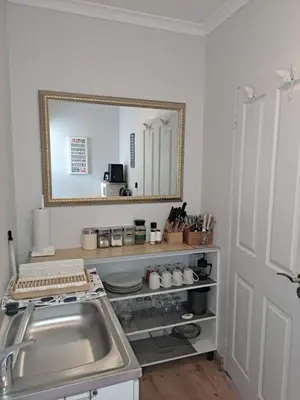 a kitchen with a sink and a mirror on the wall at Whale Tale near Kite Beach in Cape Town