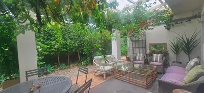 a patio with a conservatory with chairs and a table at The Lily House Hermanus in Hermanus