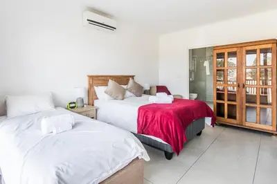 a bedroom with two beds and a window at Cornerstone Guesthouse Alk Van Zyl in Panorama