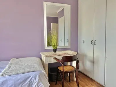 a bedroom with a bed and a table with a mirror at Princess Holiday Home in Cape Town