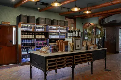 a wine store with a counter with bottles of wine at Blaauwklippen Manor by NEWMARK in Stellenbosch