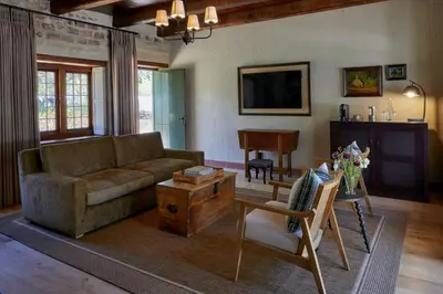 a living room with a couch and a table at Blaauwklippen Manor by NEWMARK in Stellenbosch