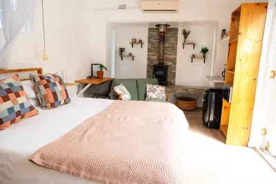 a bedroom with a large bed and a couch at 4 ON REGENT in Greyton