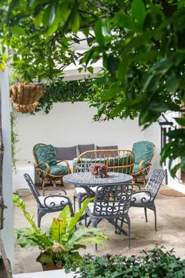 a patio with a table and chairs and trees at 4 ON REGENT in Greyton