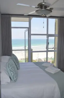 a bedroom with a bed with a view of the beach at 808 St Tropez in Cape Town