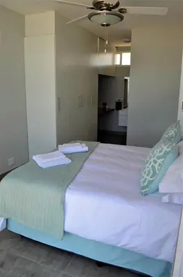 a large bed with two towels on top of it at 808 St Tropez in Cape Town