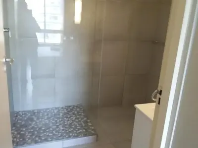 a bathroom with a shower with a bench in it at Sunset 786 Holidays 211 in Strand