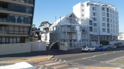 a white building on the side of a street at Sunset 786 Holiday Accom-212 in Strand