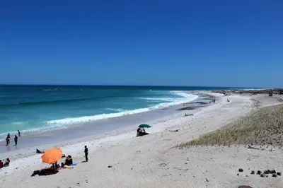 a group of people on a beach with umbrellas at 603 Nautica in Cape Town