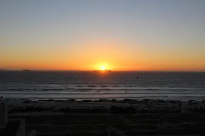a sunset over the ocean with a ship in the distance at 603 Nautica in Cape Town