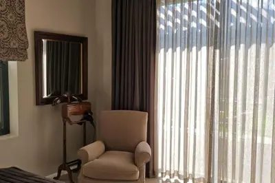 a living room with a chair and a large window at Farm Stay Winelands in Paarl
