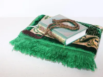a book with a rosary sitting on top at The Noble Lodge in Cape Town
