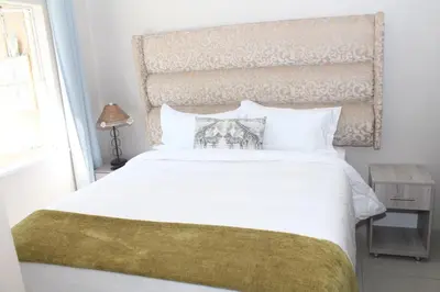a bedroom with a large white bed and a window at MO MAJOR in Cape Town