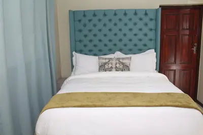 a bedroom with a large bed with a blue headboard at MO MAJOR in Cape Town