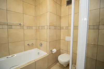 a bathroom with a bath tub and a toilet at Hibernian Towers 402 Self Catering Accommodation Strand Western Cape South Africa in Cape Town