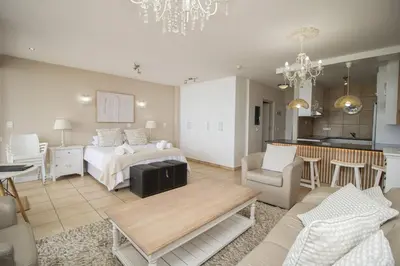 a large living room with a bed and a kitchen at Hibernian Towers 402 Self Catering Accommodation Strand Western Cape South Africa in Cape Town