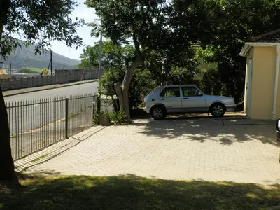 a white car parked in a driveway next to a tree at 10 on Fairview B&B in Paarl