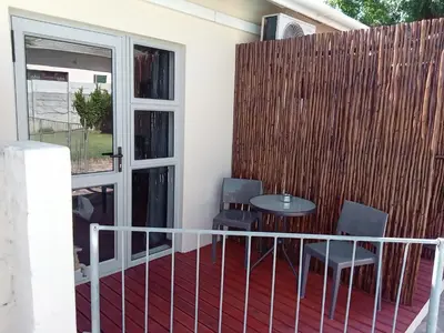 a balcony with a table and chairs and a fence at 10 on Fairview B&B in Paarl