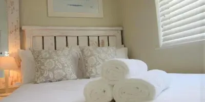 a bed with two towels on top of it at 57 Whale Rock Estate in Hermanus