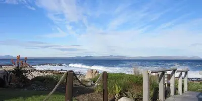 a path leading to a beach with the ocean at 57 Whale Rock Estate in Hermanus