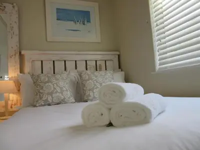 a white bed with towels on top of it at 57 Whale Rock Estate in Hermanus